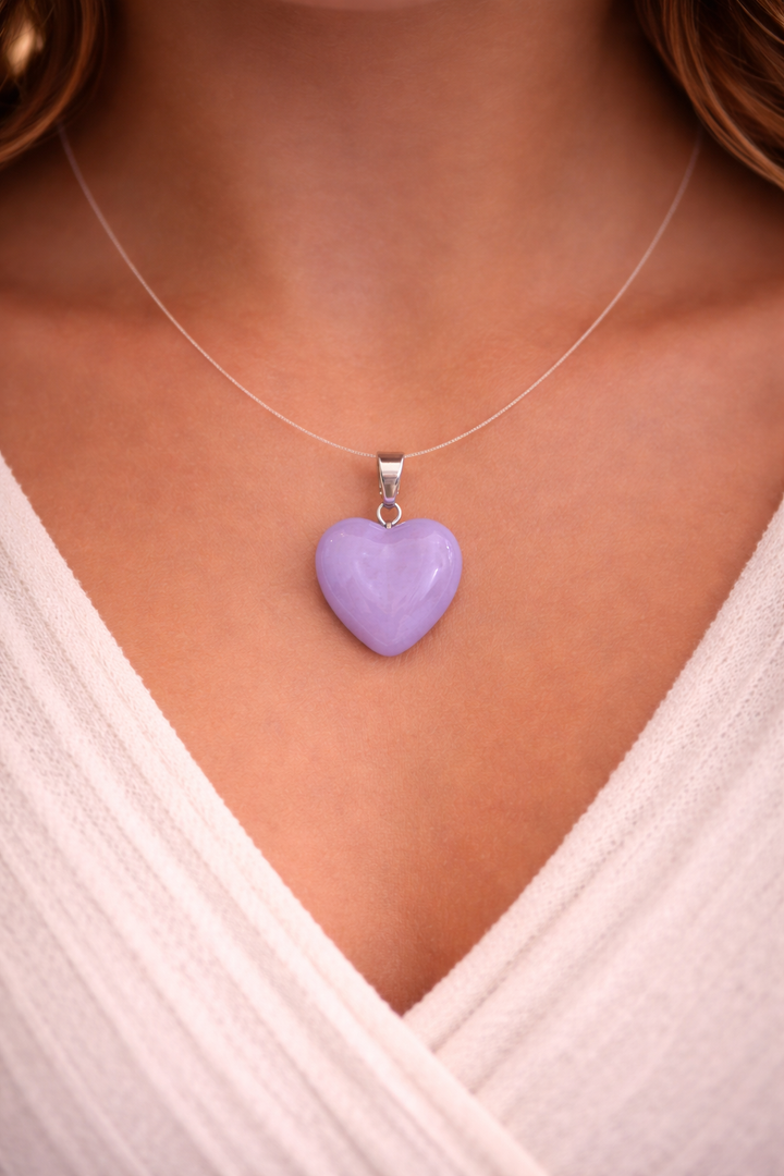 Purple heart-shaped pendant on a necklace against a neutral background