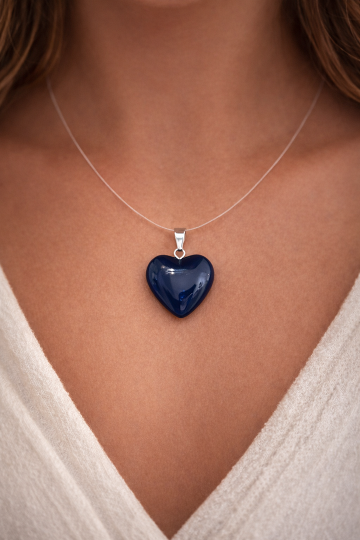 Blue heart-shaped pendant on a necklace against a neutral background