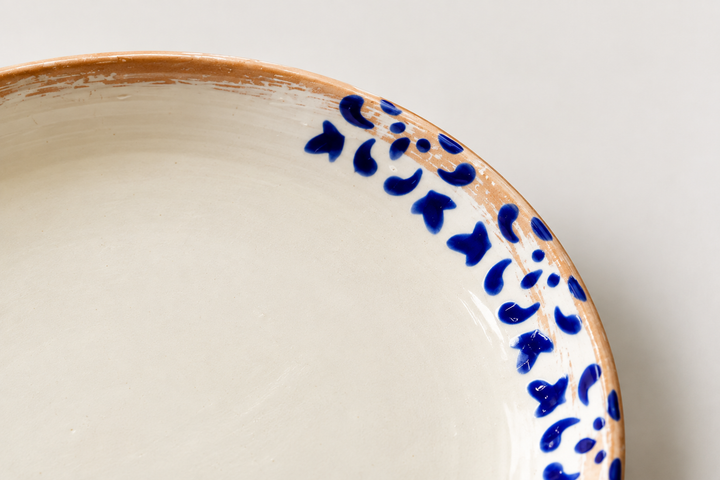 Close-up of cobalt blue hand-painted details on handmade glazed ceramic plate