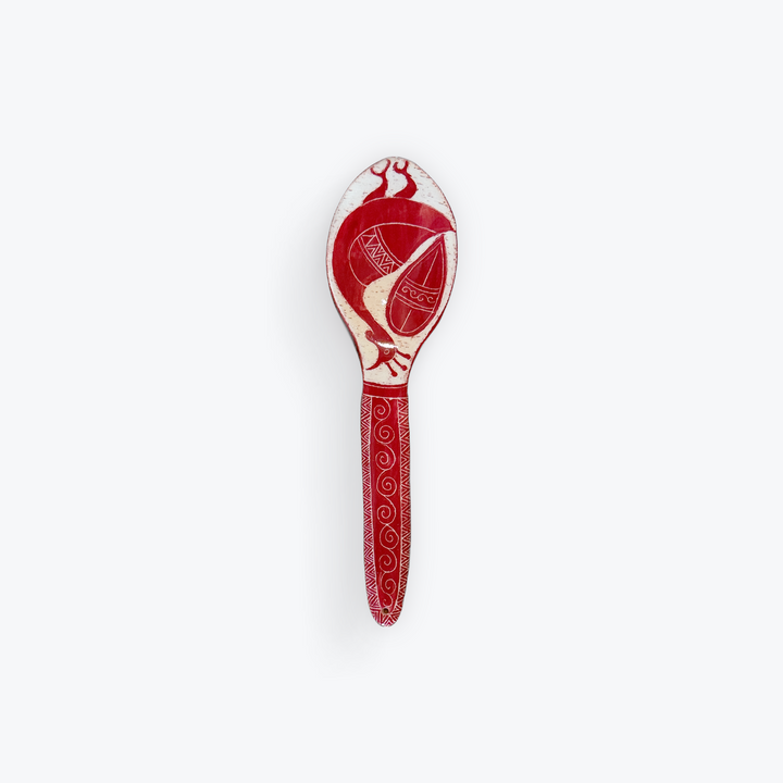 A red and white decorative spoon featuring a stylized bird design on the bowl and intricate scrollwork patterns on the handle, set against a plain light gray background.