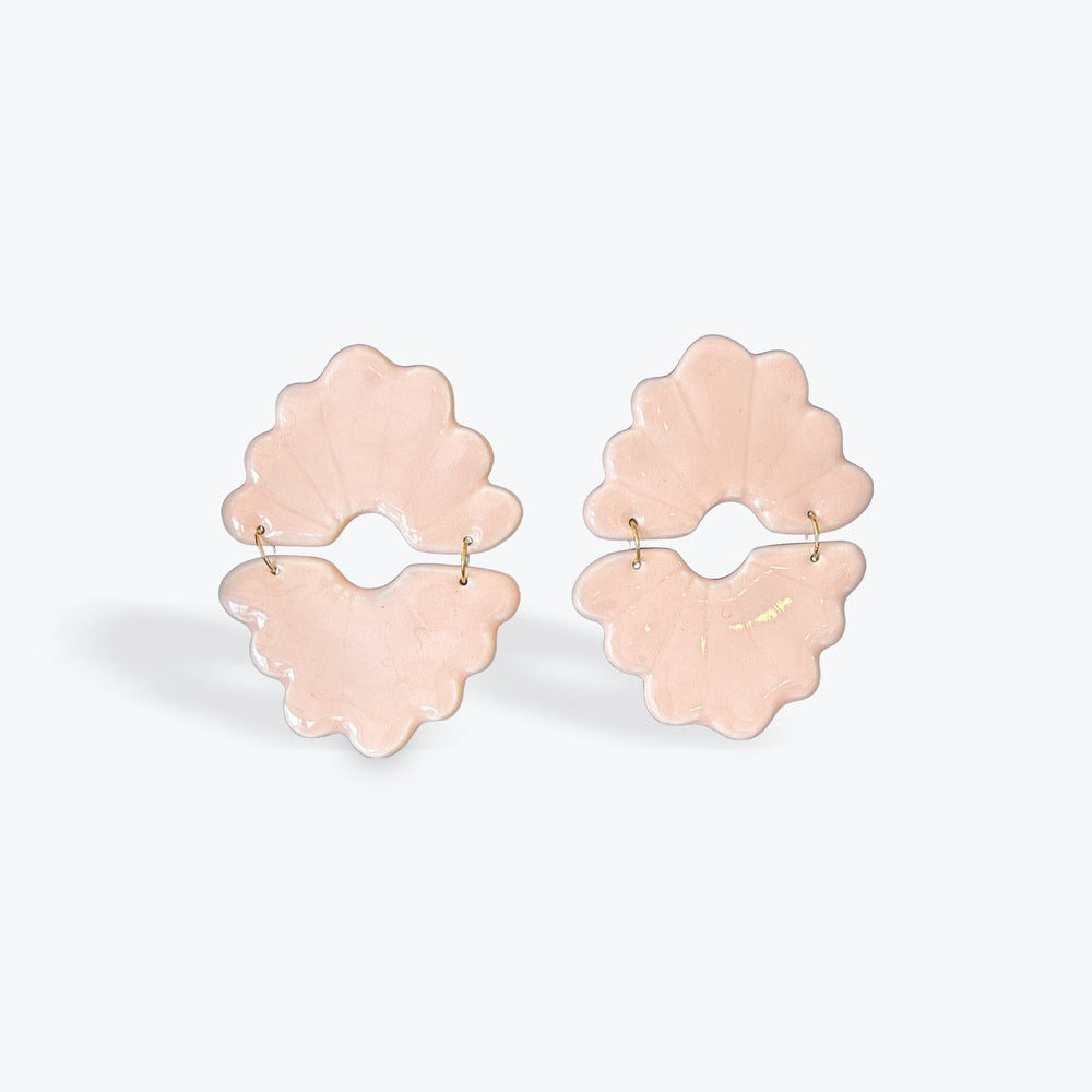A pair of light pink flower-shaped hoop earrings with small gold posts, displayed on a clean white background.
