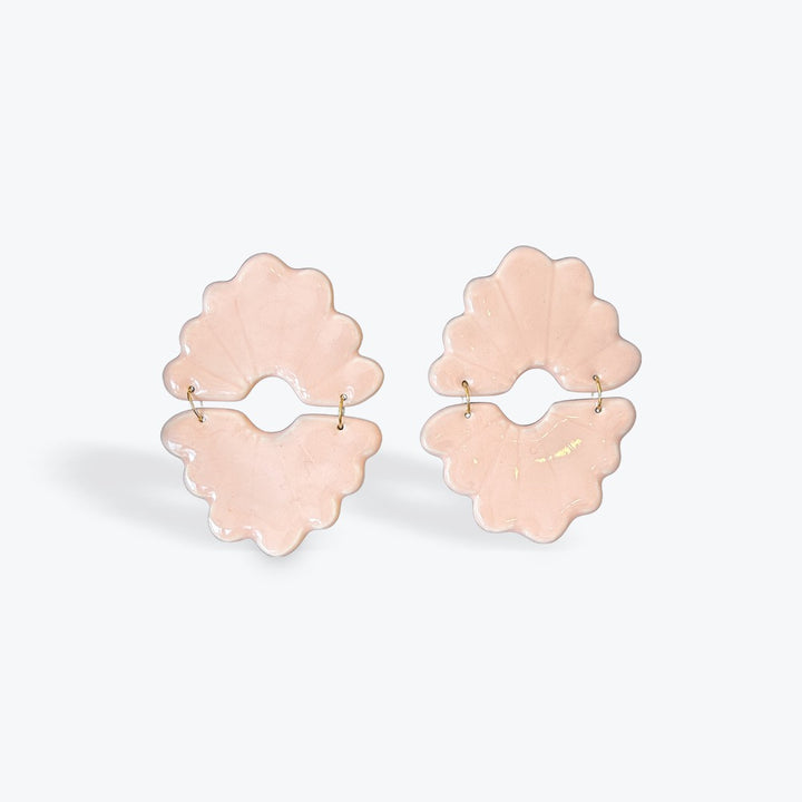 A pair of light pink flower-shaped hoop earrings with small gold posts, displayed on a clean white background.