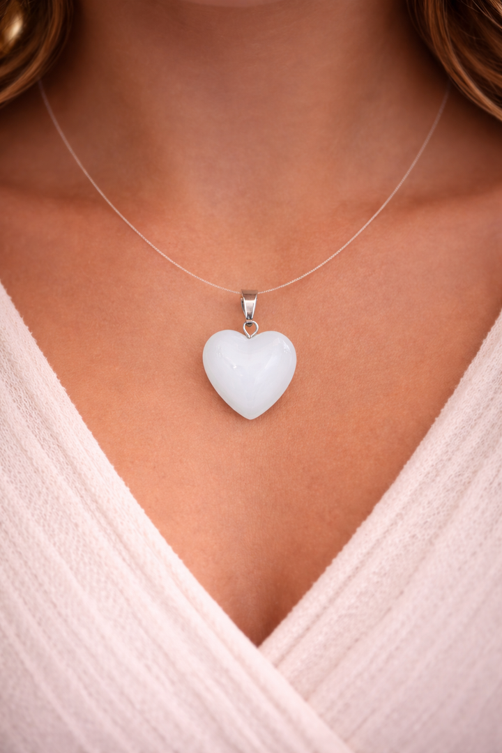 Heart-shaped pendant necklace on a person wearing a light pink top