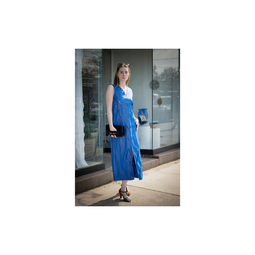 Woman in a blue dress standing in front of a store window
