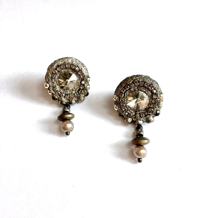 A pair of vintage-style dangle earrings with oxidized silver-toned metalwork, clear faceted center stones, and small pearl-like beads, shown on a plain white background.