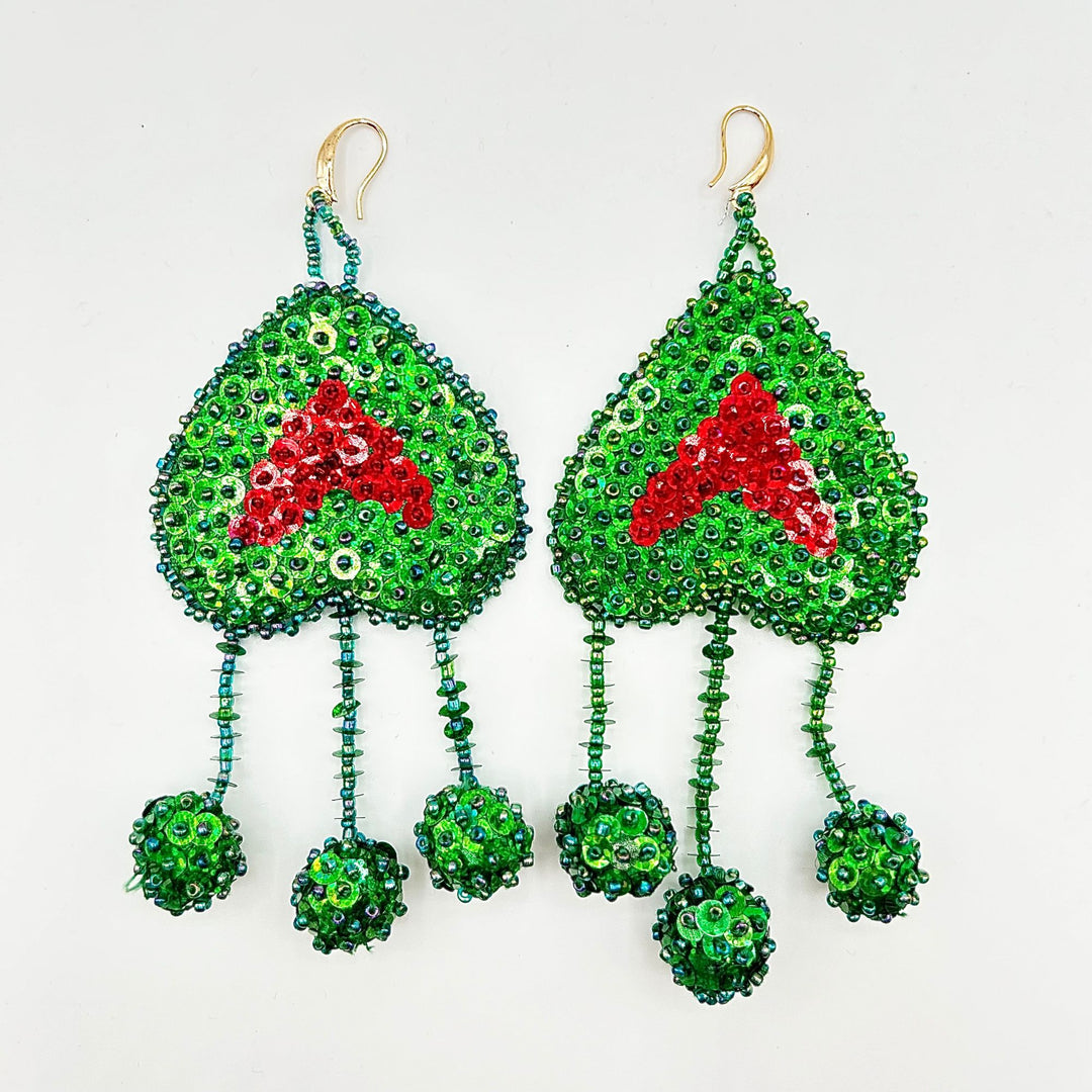Pair of green beaded earrings with red heart design on a white background