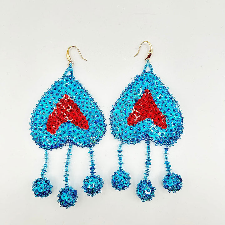 Blue beaded earrings with red heart-shaped charms on a white background