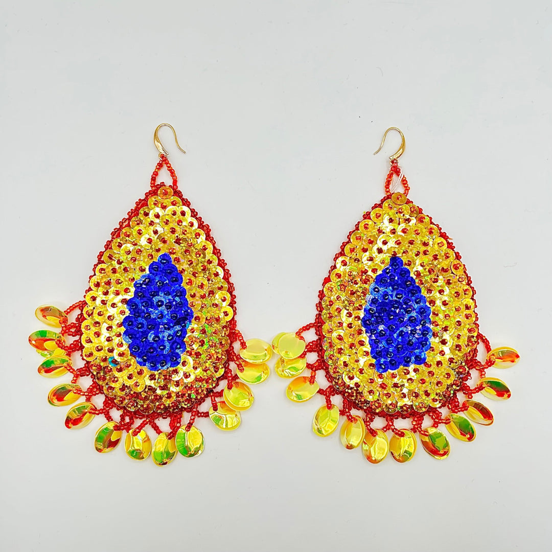 A pair of large, ornate teardrop-shaped dangle earrings decorated with yellow sequins, a central royal blue sequin motif, and red beaded borders with dangling multicolored faceted beads on a light gray background.