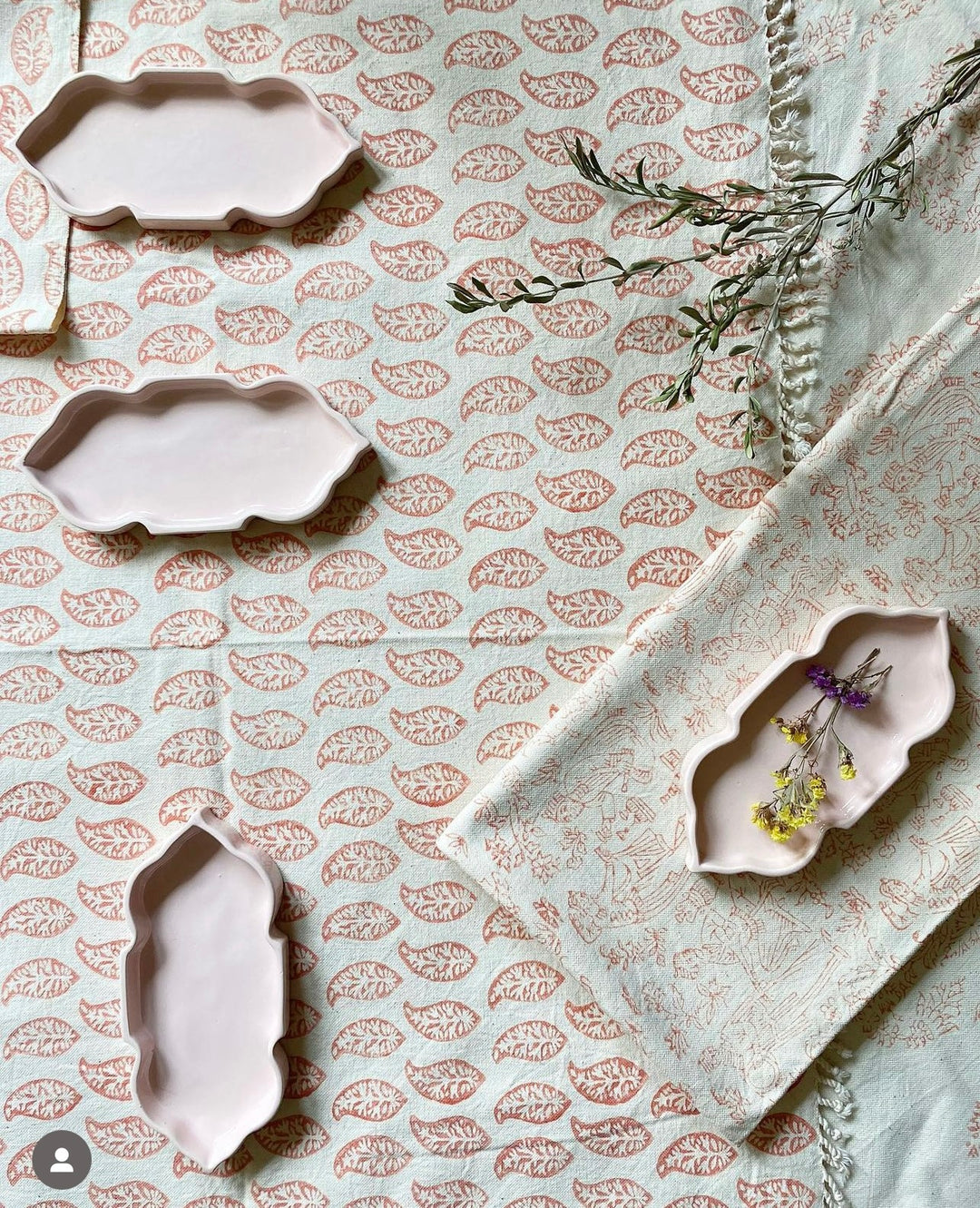 Decorative ceramic trays with floral patterns on a textured fabric background