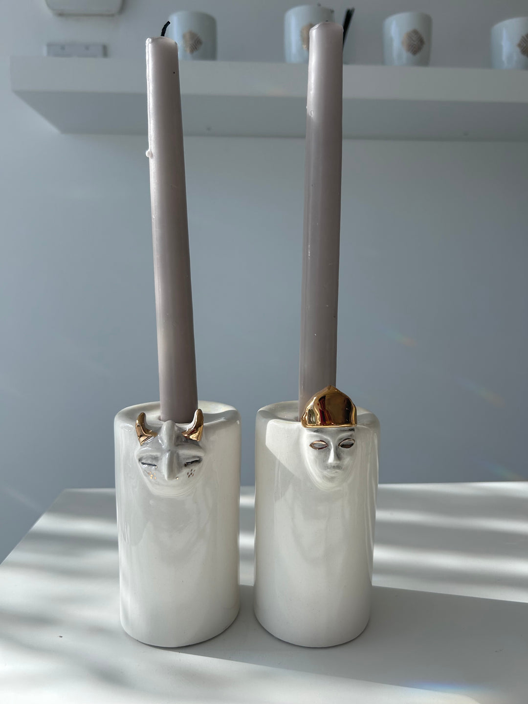White cylindrical objects with gold accents on a white background