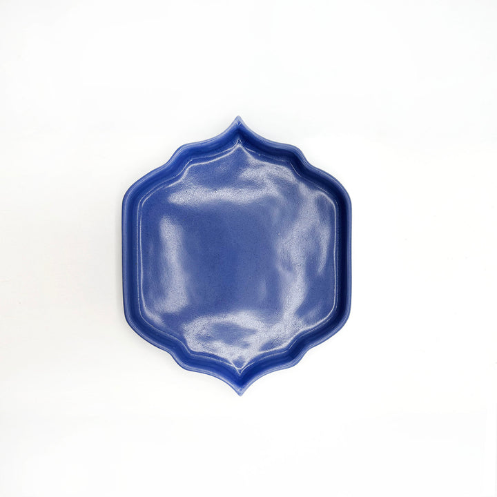 Blue ceramic plate with a decorative edge on a white background
