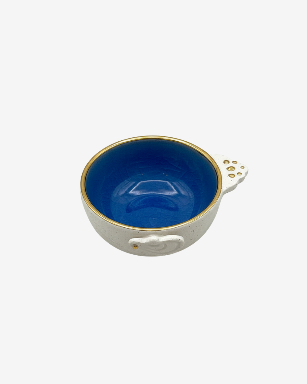 Blue ceramic bowl with gold interior on a white background